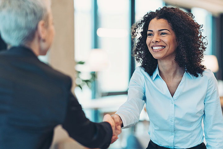 two colleagues shaking hands and greeting each other