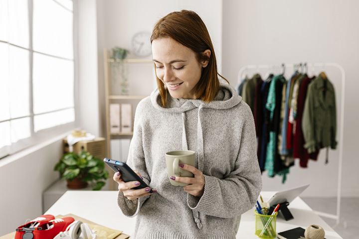 FindBranch_720x480 Woman at home holding mug and cell phone