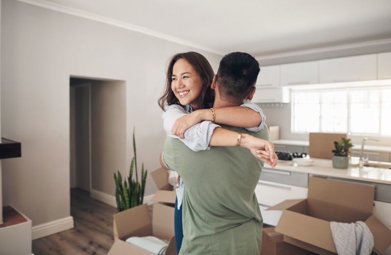 Happy couple in their new home with moving boxes