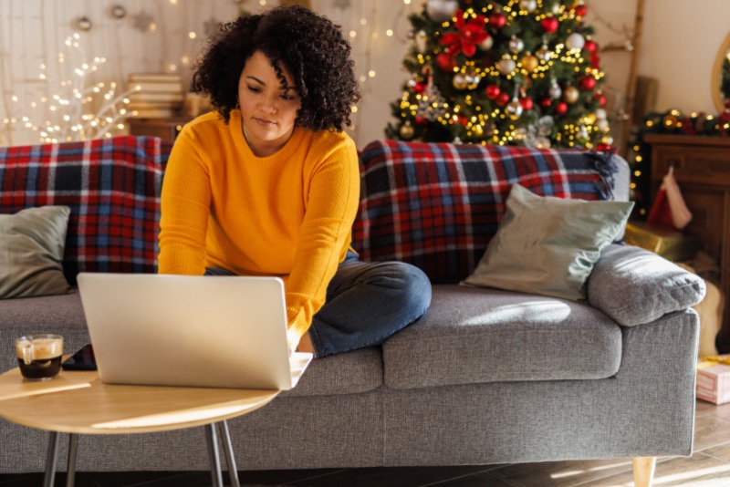 Woman at computer with holiday decor in the room