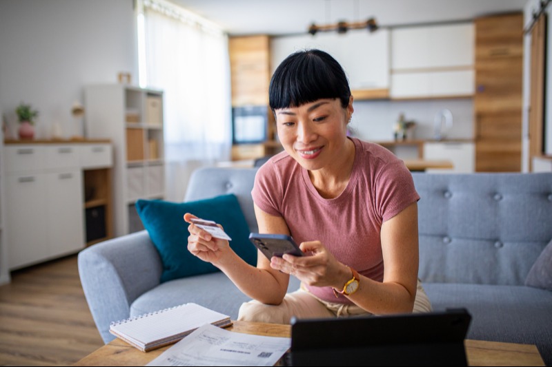 Woman with tablet and phone managing finances at home