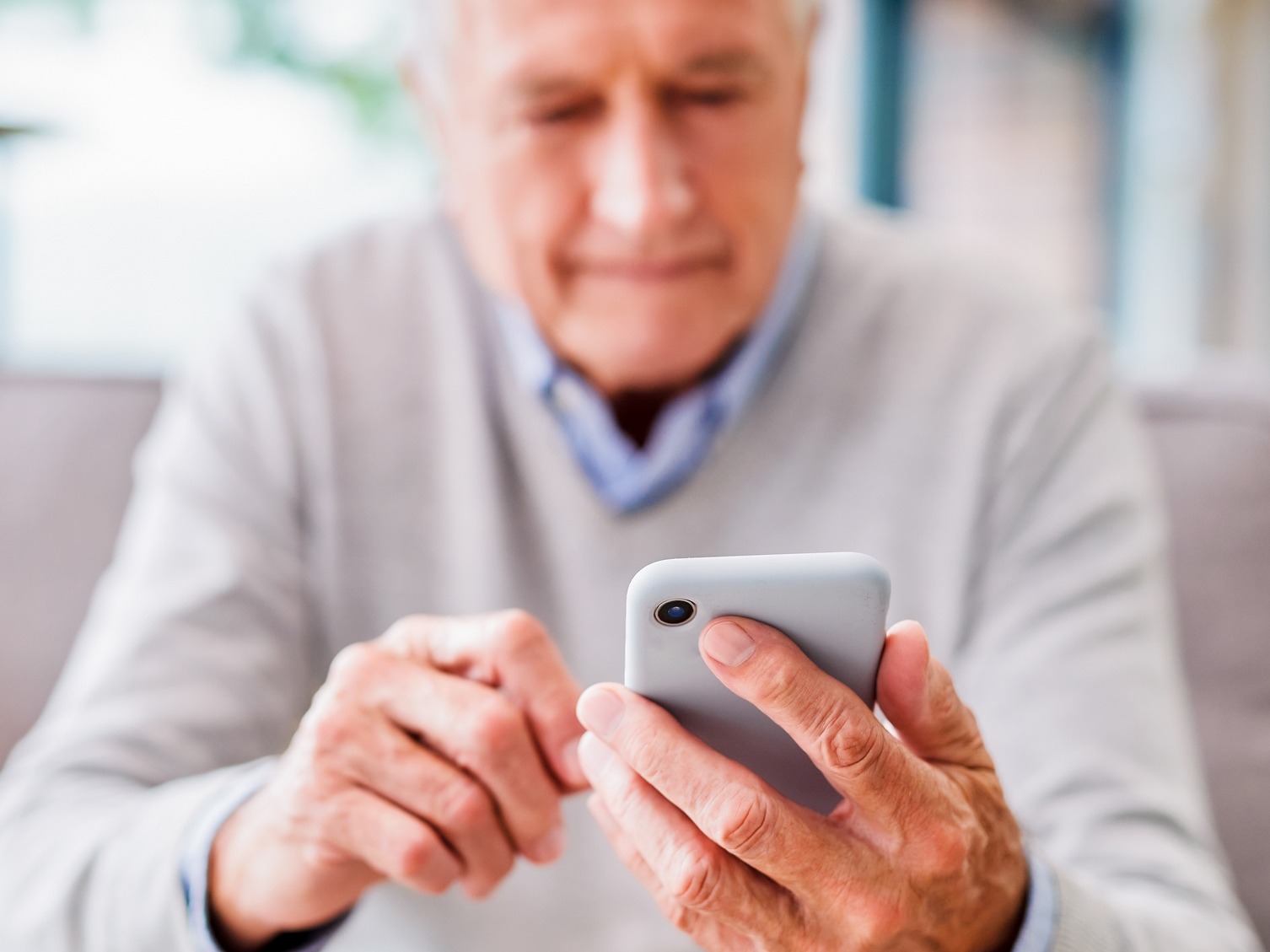 elderly man looking at phone