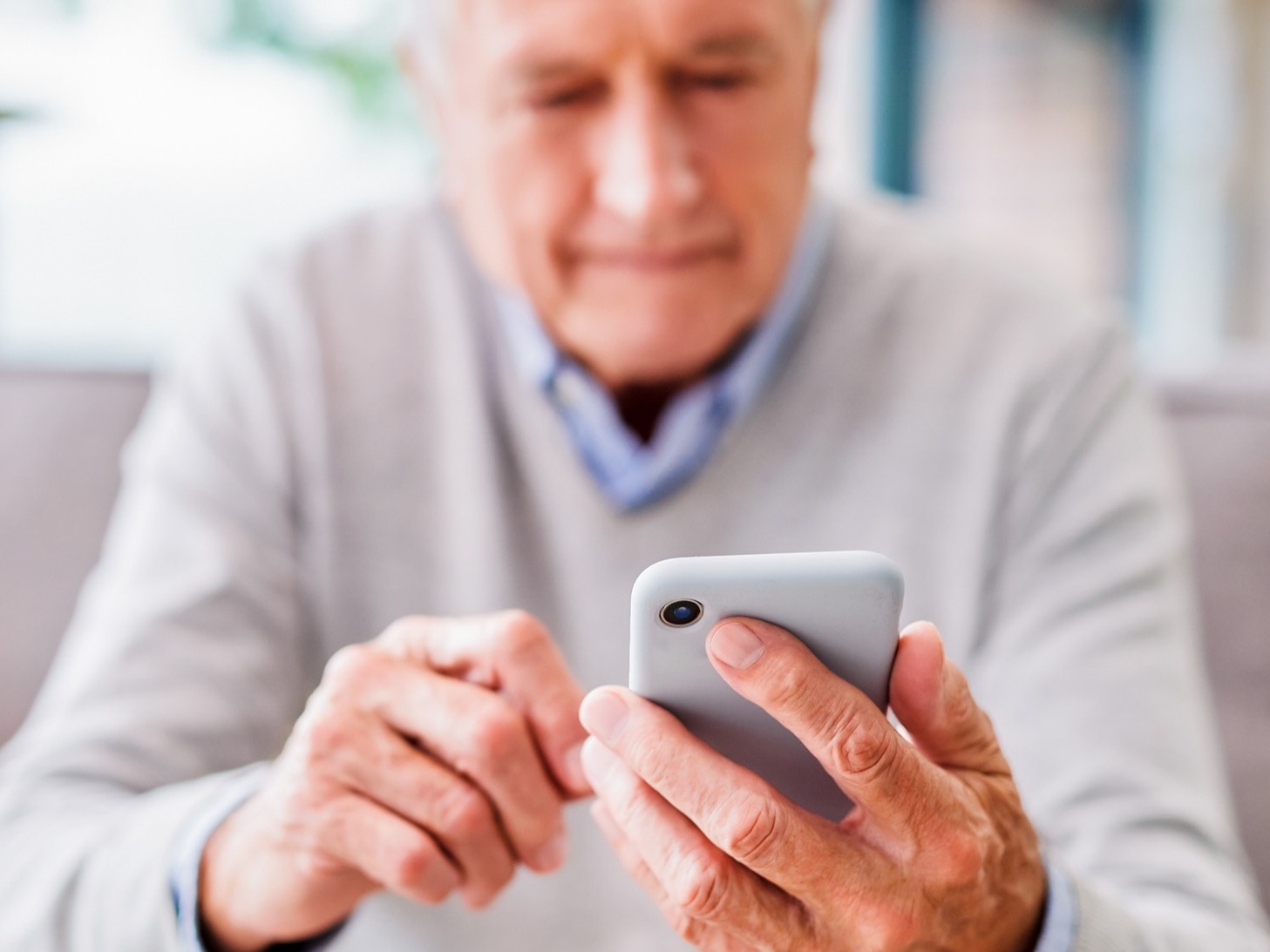 elderly man looking at phone