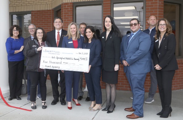 A group of people present a large check in front of Liberty Bank