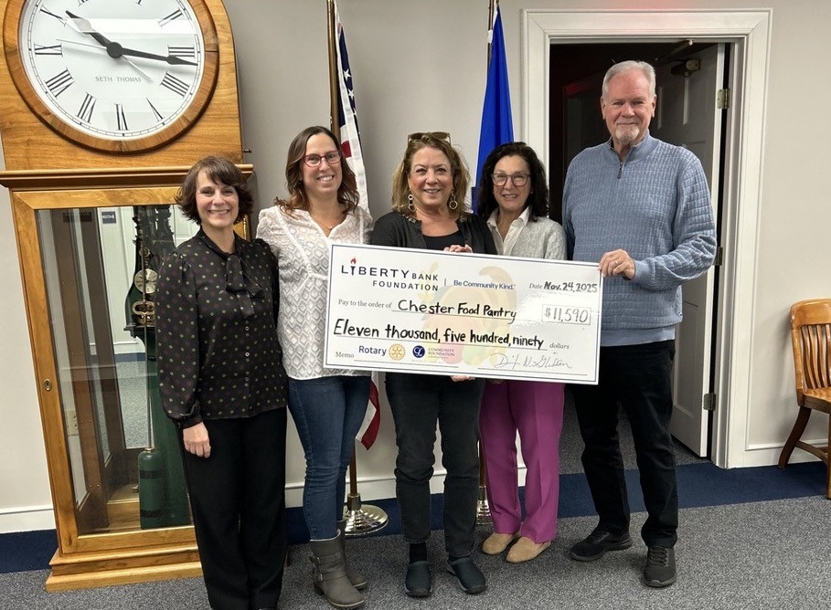 Five people holding a large presentation check