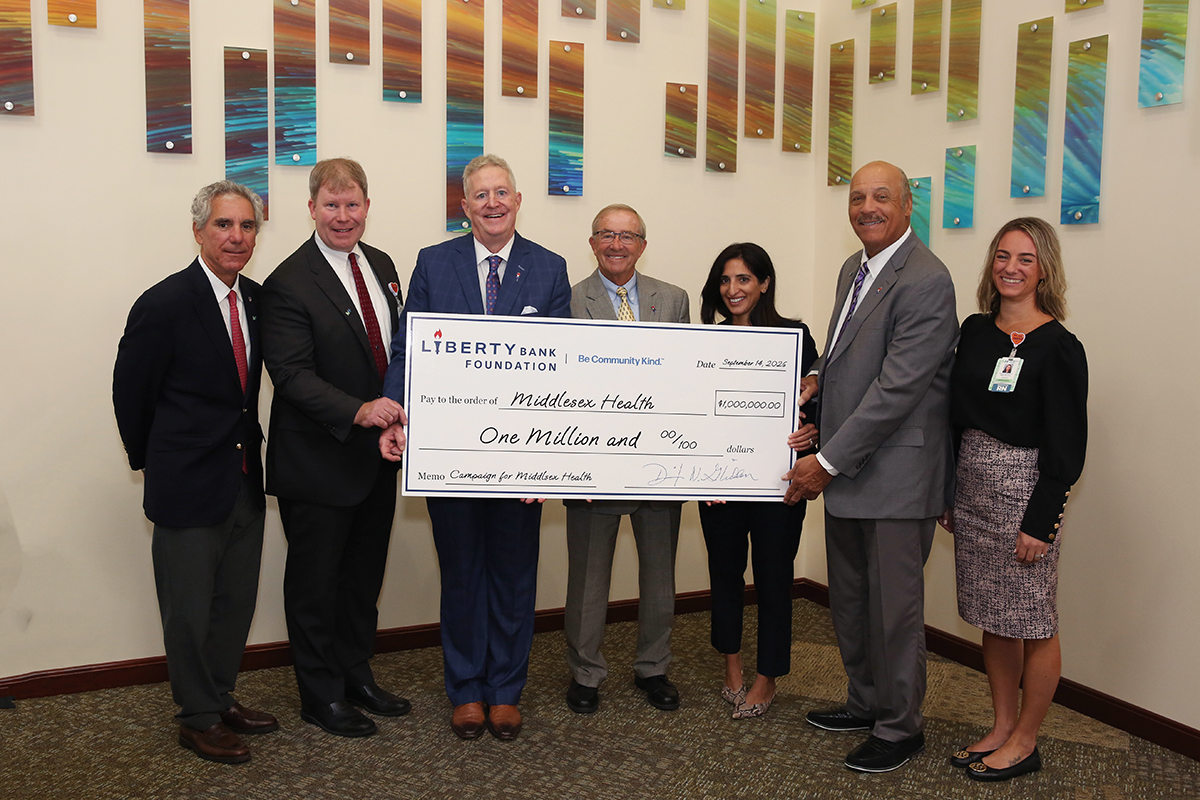 Several people holding a presentation check