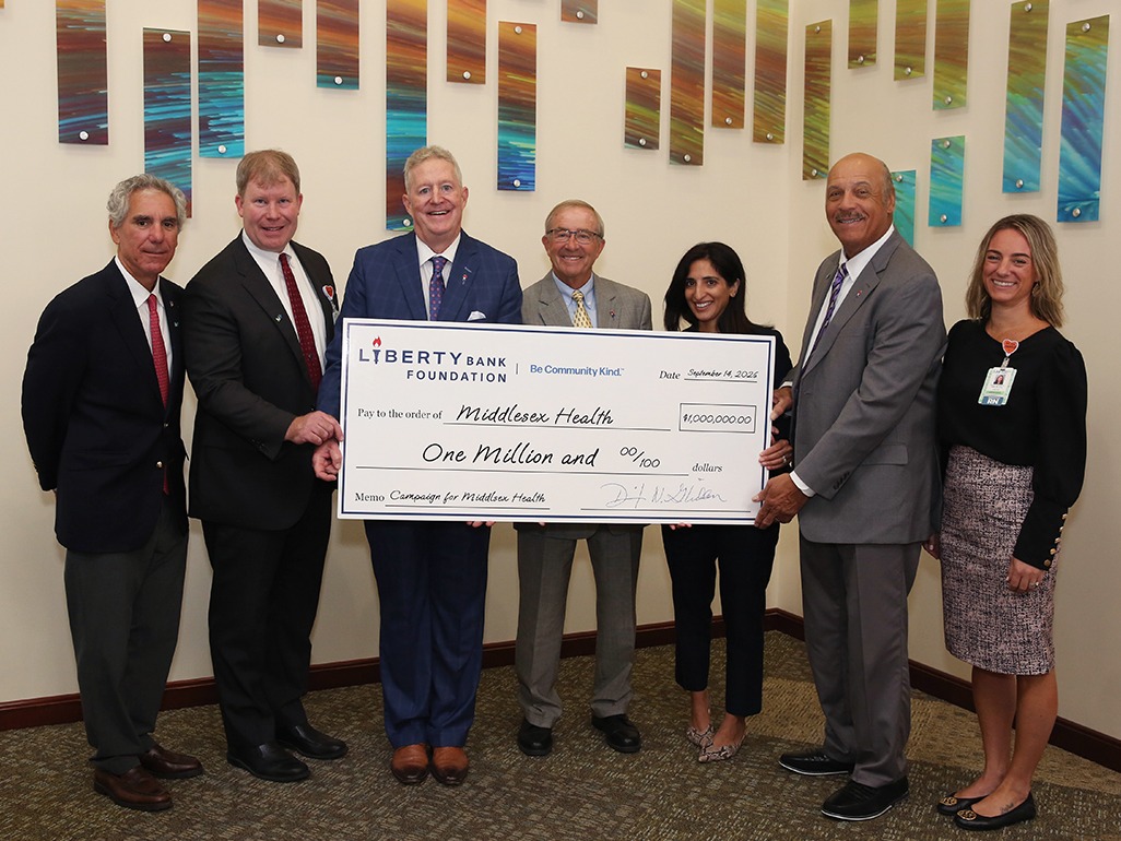 Several people holding a presentation check