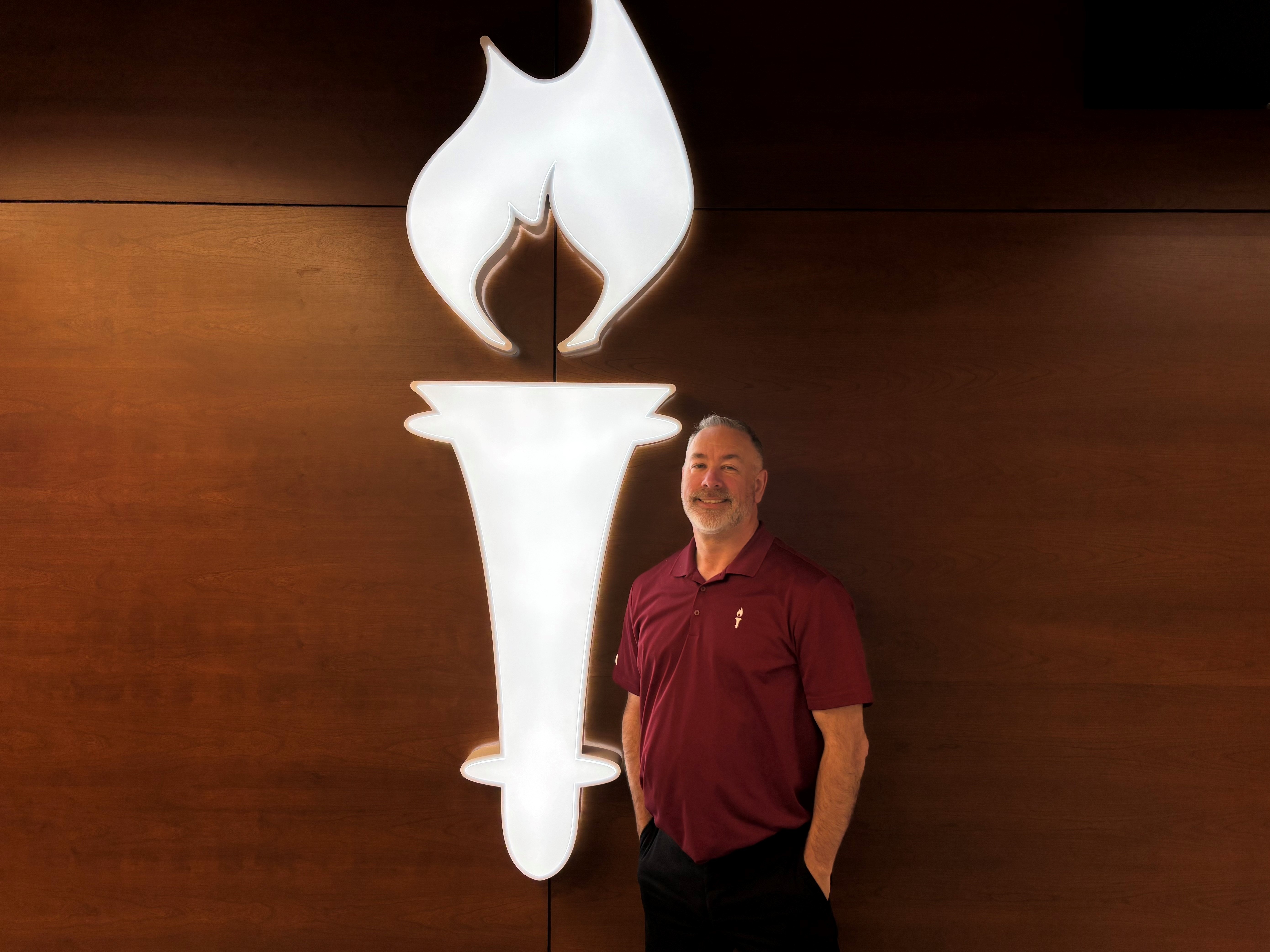 Liberty Bank Teammate Armand Fortier in Front of Light Up Torch