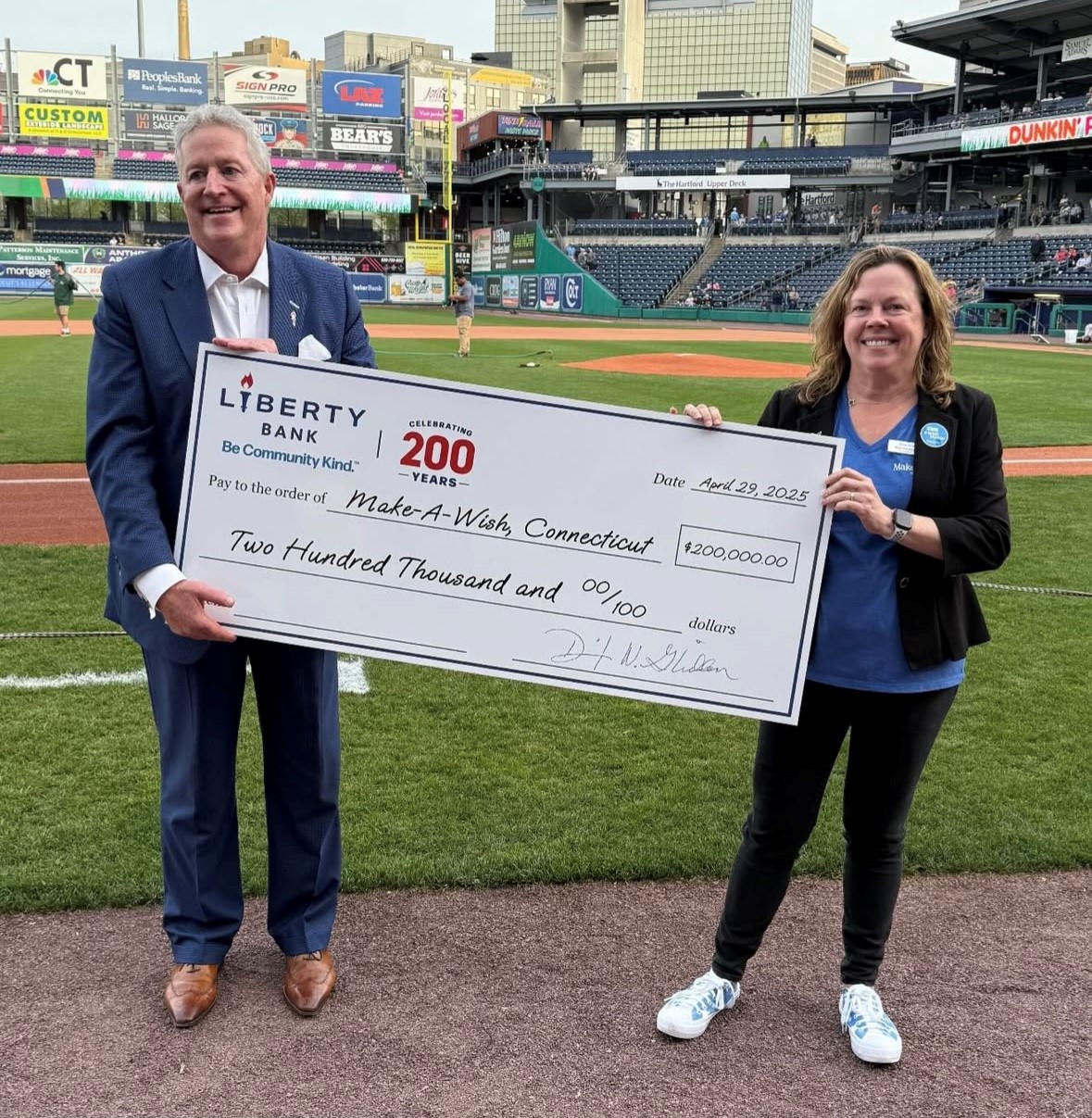 two people holding $200,000 check presentation to make-a-wish